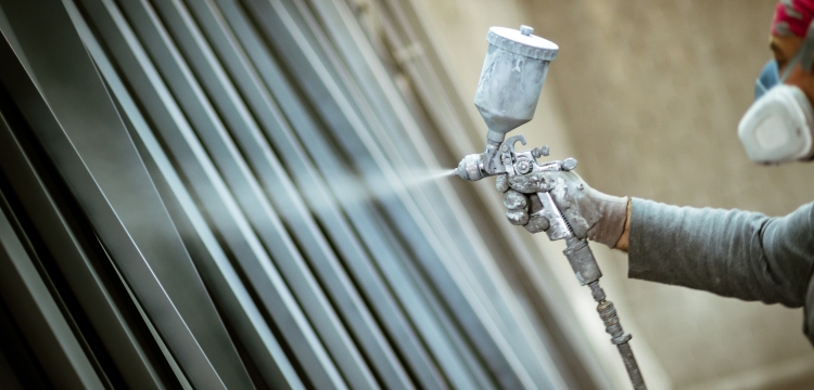 Homme peignant sur une pièce métallique anticorrosion